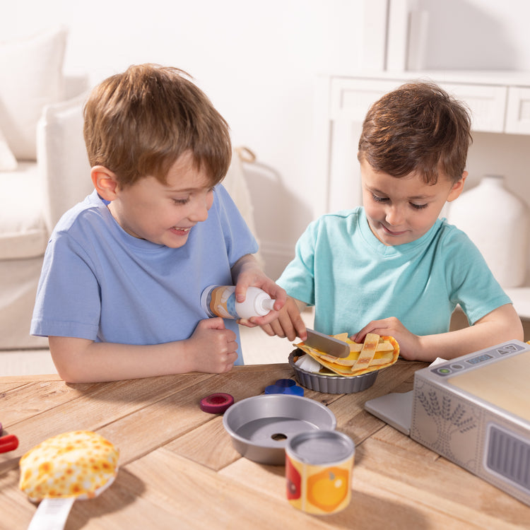 A kid playing with The Melissa & Doug Make and Bake Pies Pretend Play Food Set And Wooden Oven With Squishy Dough for Ages 3+