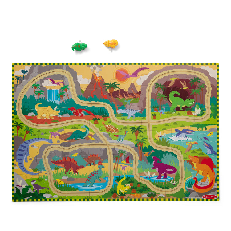 The loose pieces of The Melissa & Doug Dinosaur Adventure Tracks Cardboard Jigsaw Floor Puzzle and 2 Wind-Up Dinos – 48 Pieces, for Boys and Girls 3+ 