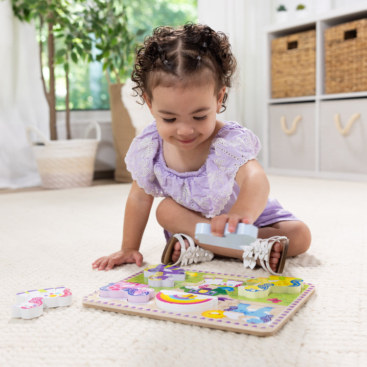 A kid playing with The Melissa & Doug Wooden 6-Piece Unicorn and Rainbow Chunky Puzzle for Toddler Boys and Girls 2+