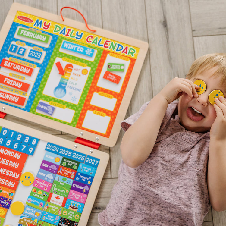 A kid playing with The Melissa & Doug My First Daily Magnetic Calendar